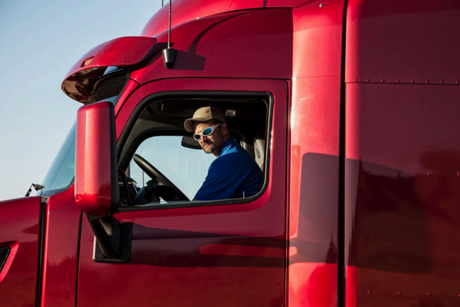 Man looking out of red semi truck