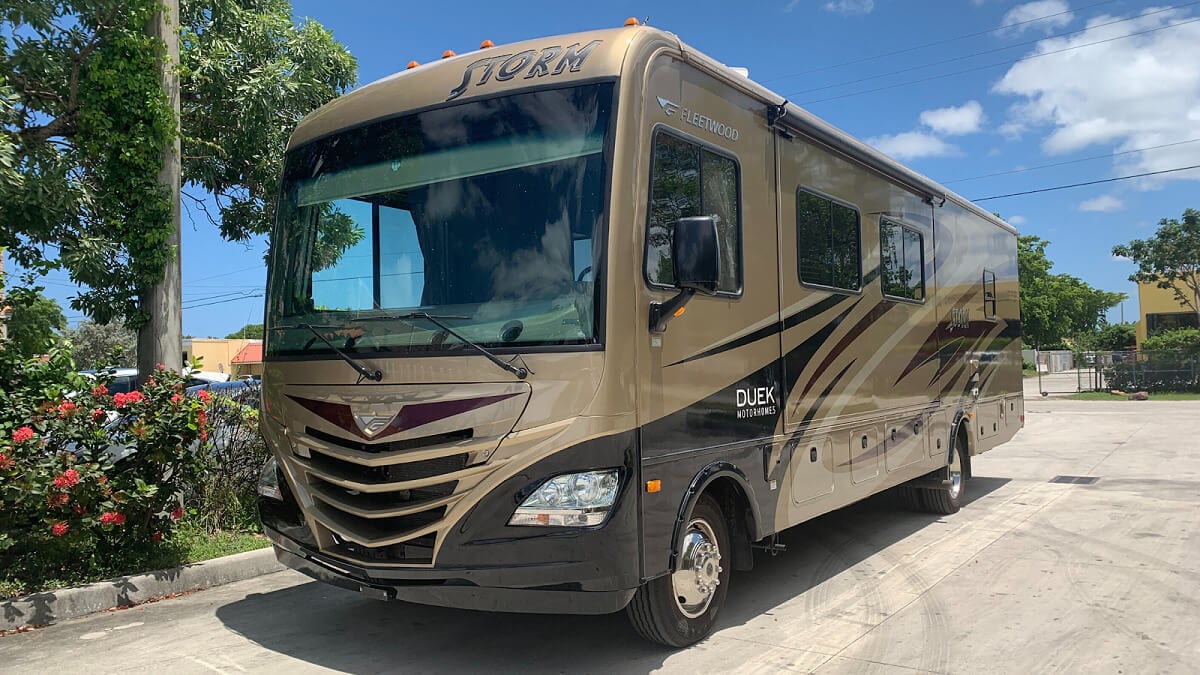 Brown RV parked in a lot.