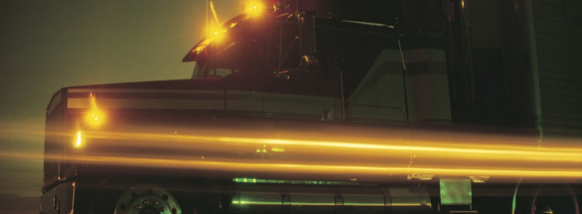 Semi truck with lights on at night.