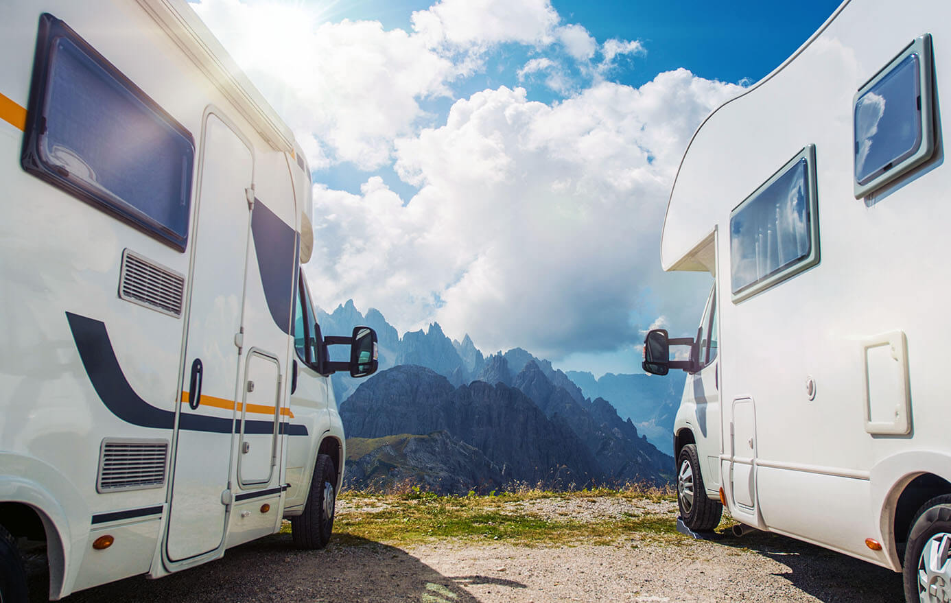 Two RVs marked at the edge of a mountain.