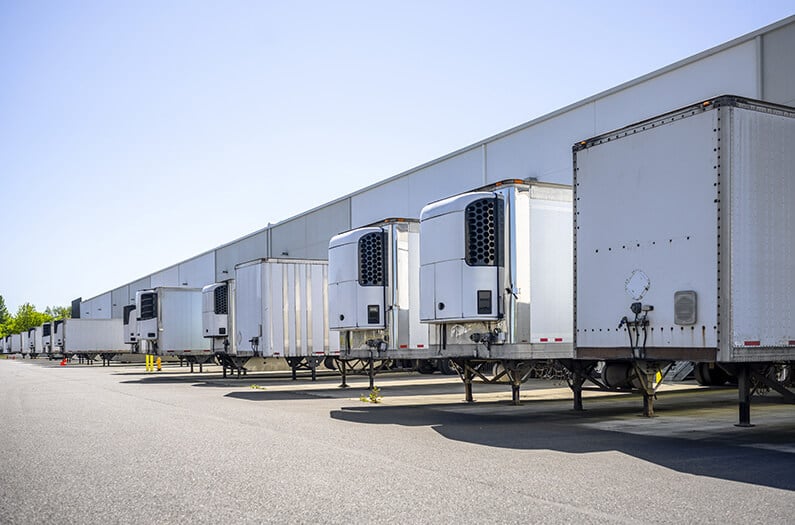 Reefer and dry vans parked at a warehouse.